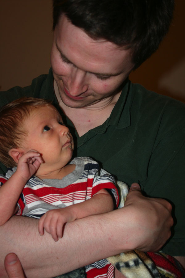 <p>Aaron holding Christian, while Christian looks at him</p>