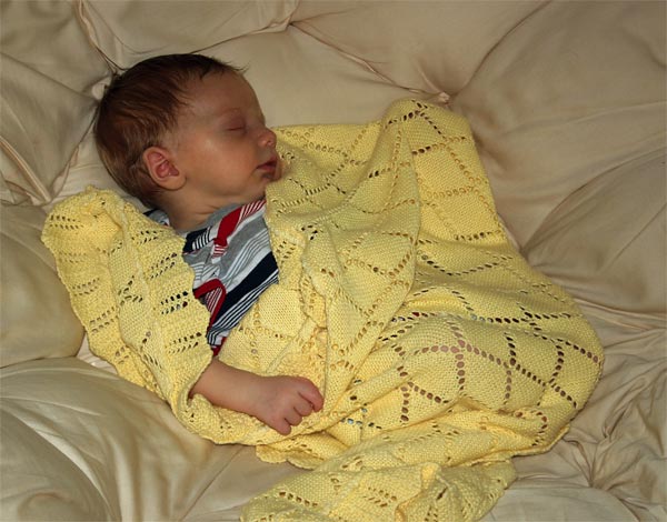 <p>Christian sleeping in the papasan with his yellow blanket</p>